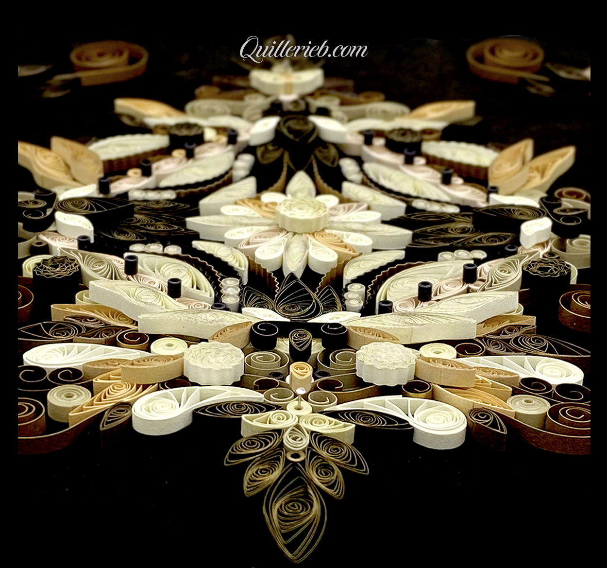 Free-form quilling in creams and muted greens centered slanted backwards view.