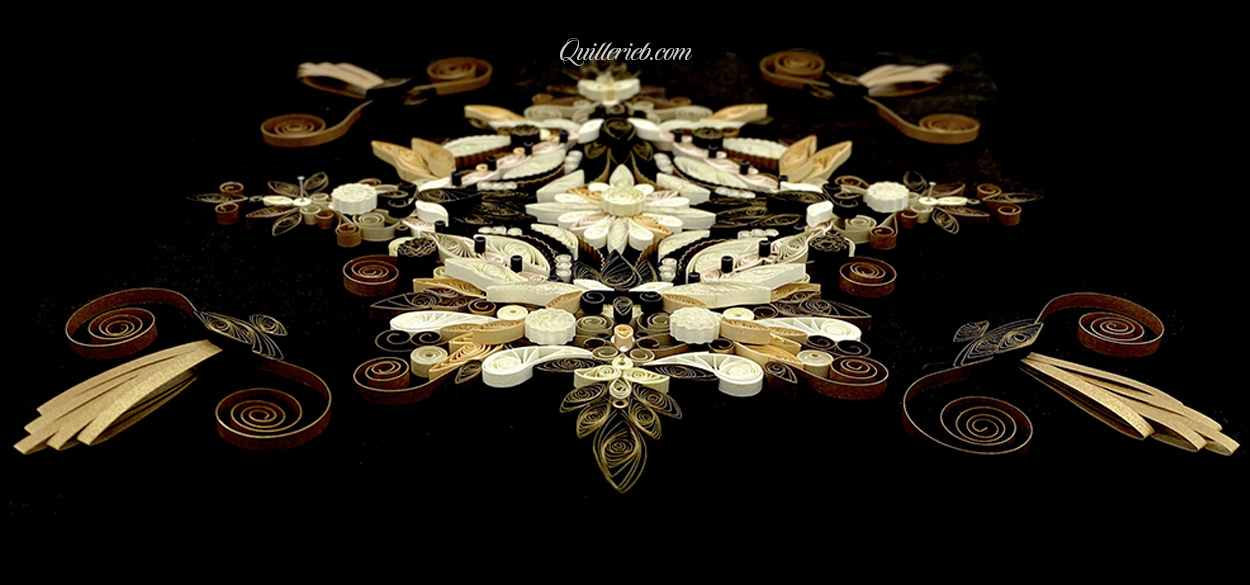 Free-form quilling in creams and muted greens wide angle slanted backwards view.