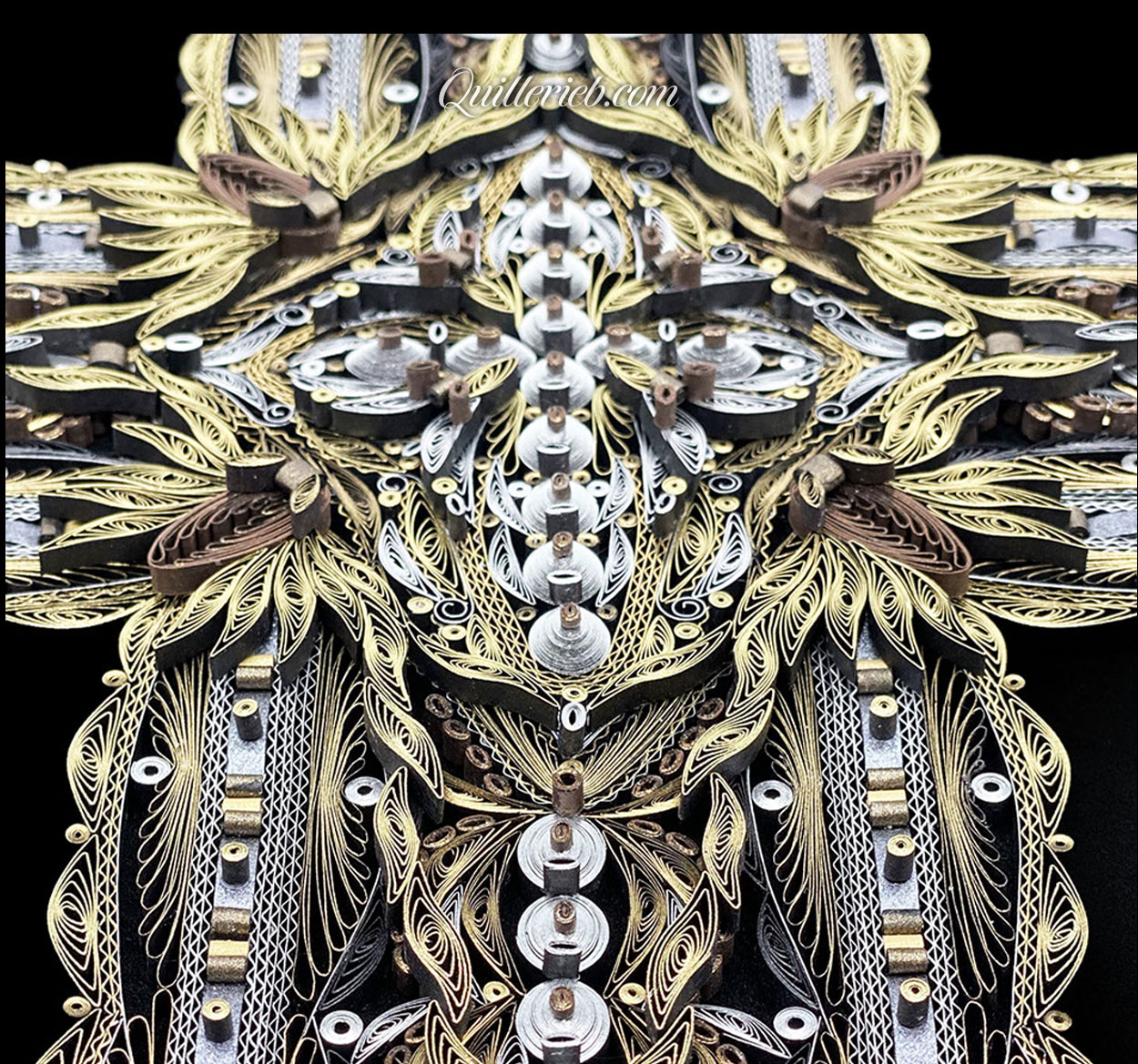 Image of quilled cross gold and silver middle section slanted backward.