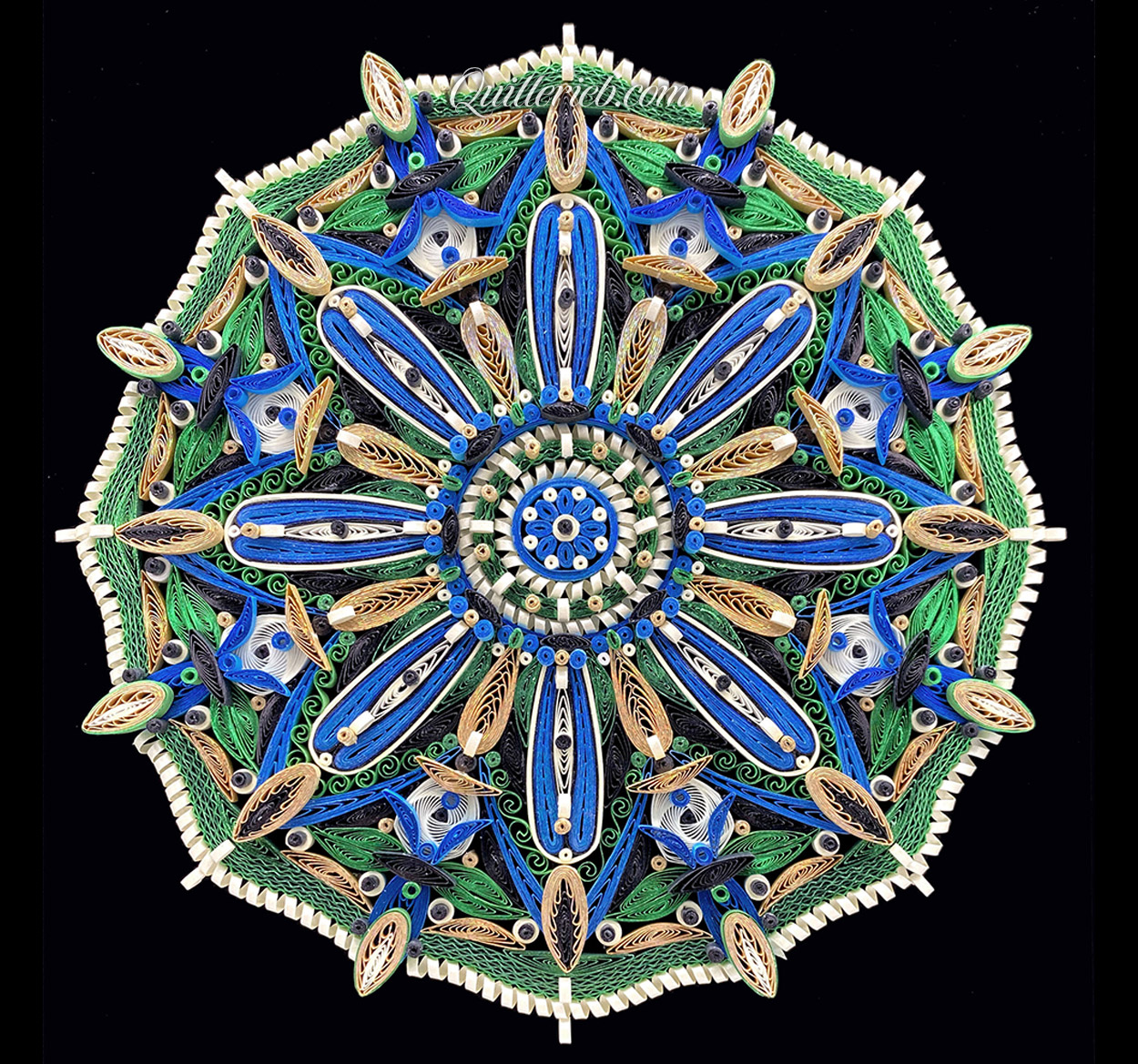 Circular quilled design in green, blue and white tones full view.