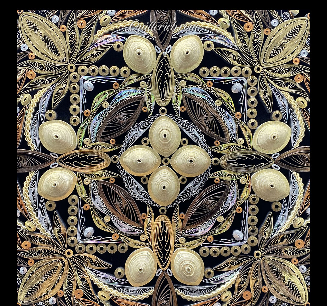 Circular quilled design in muted metallic color tones close-up view.