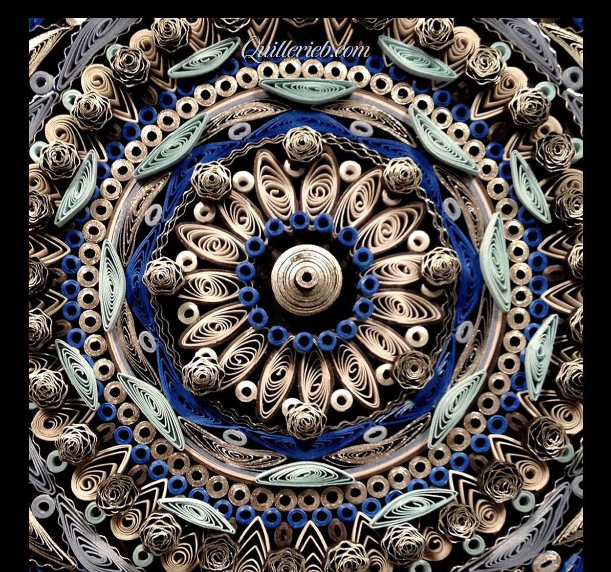 Circular quilled design in muted metallic blue and white color tones close-up view.