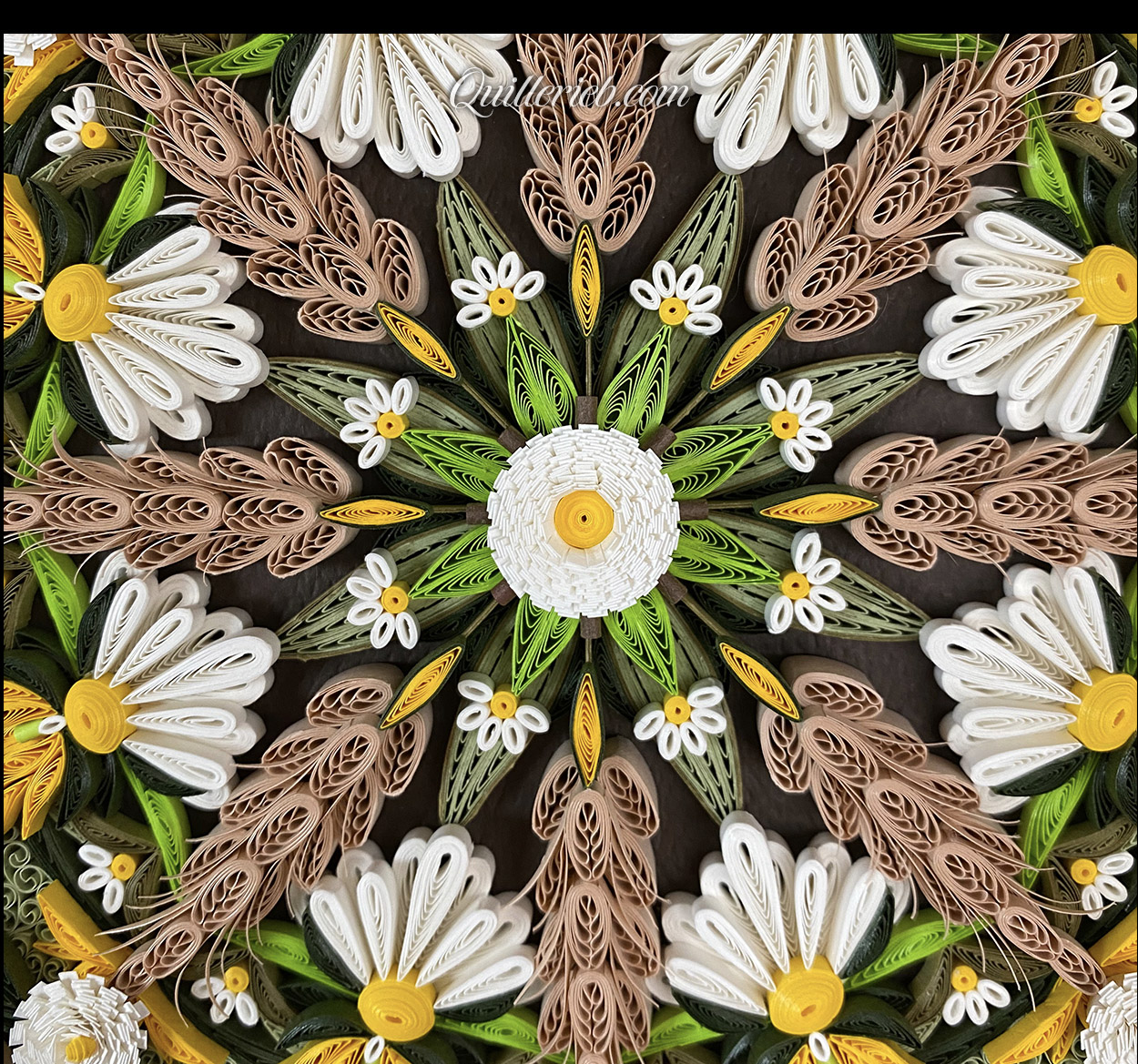 Circular quilling in green, brown, gold and white colors close-up center view.