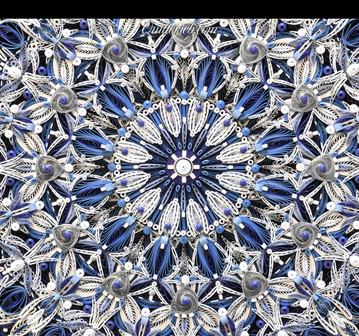 Circular quilling in blue and white colors close-up center view.