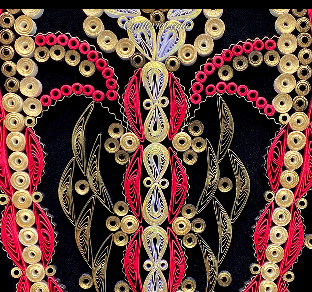 Oblong heart shape quilling in creams and reds close-up view.