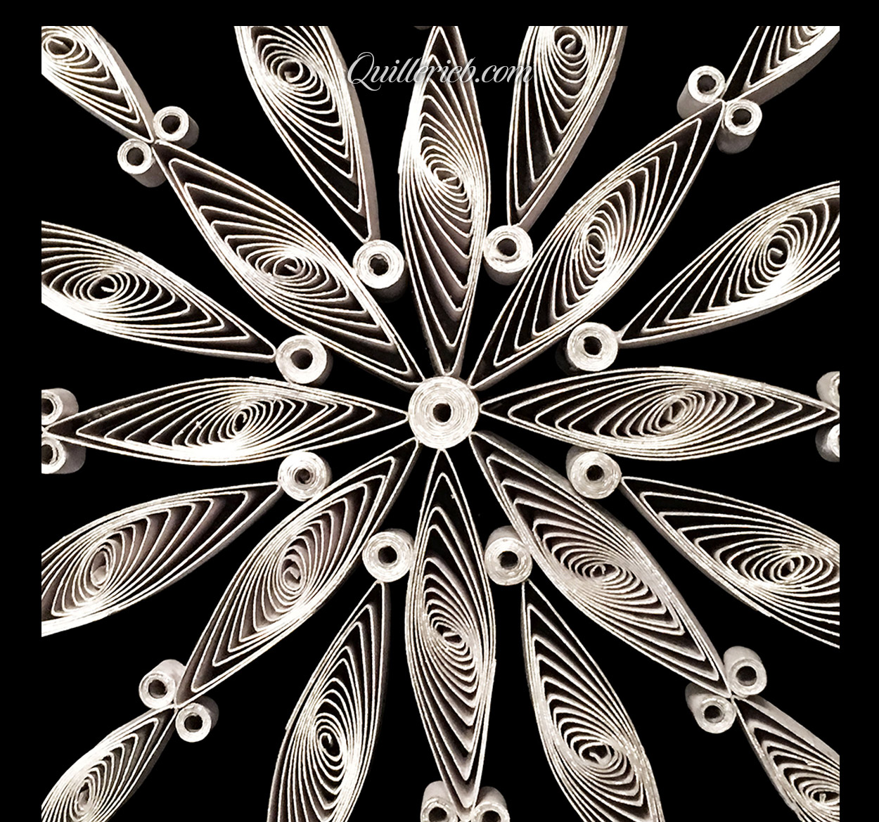 8-pointed quilling star in white, snowflake design center close-up view.