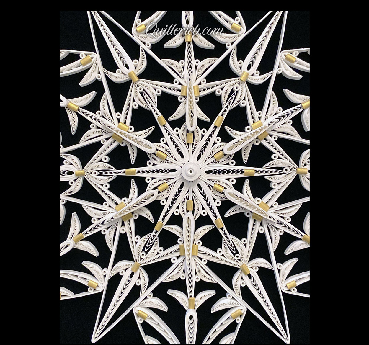12-Point Star quilling design in white with touches of gold tones center close-up view.