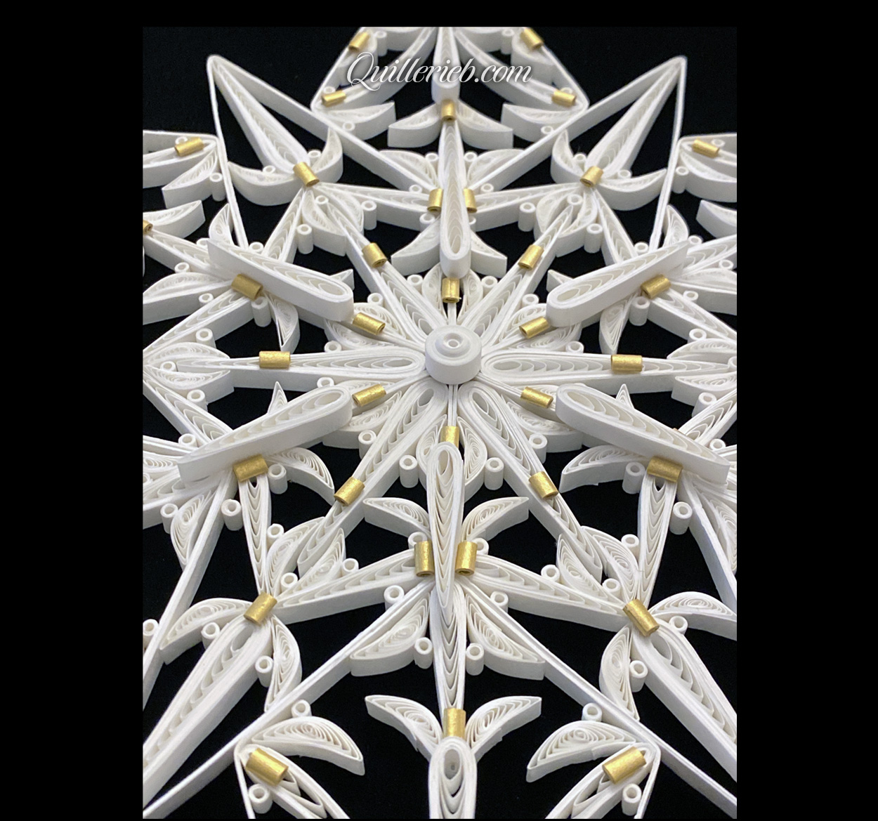 12-Point Star quilling design in white with touches of gold tones centered perspective angled backwards view.