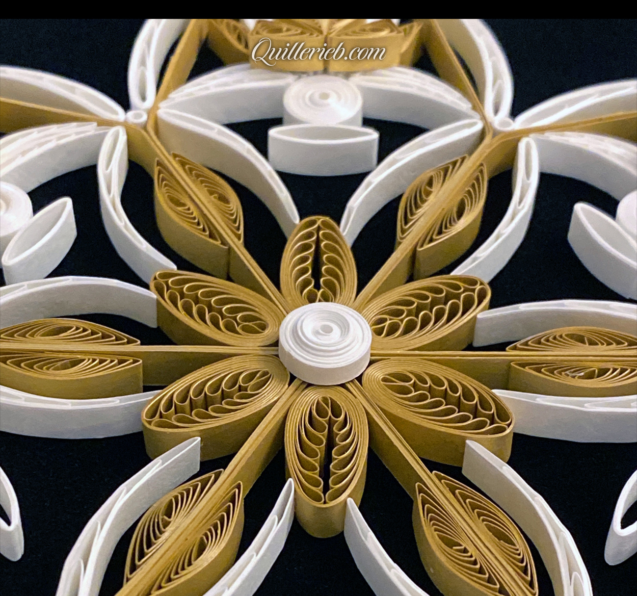 6-Point Star quilling design in white with elements of brown tones centered close-up angled backwards view.